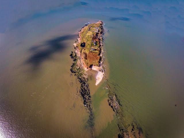 Aerial view of Hilbre Island surrounded by the sea at high tide